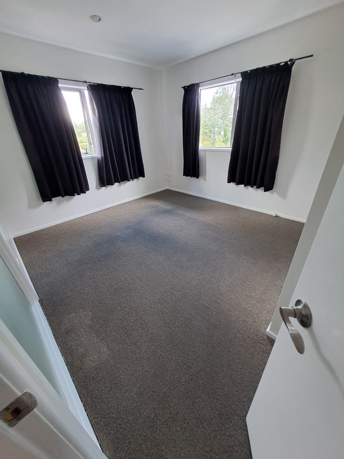 Freshly painted bedroom with white walls, black curtains and grey carpet - Ambient Civil Auckland