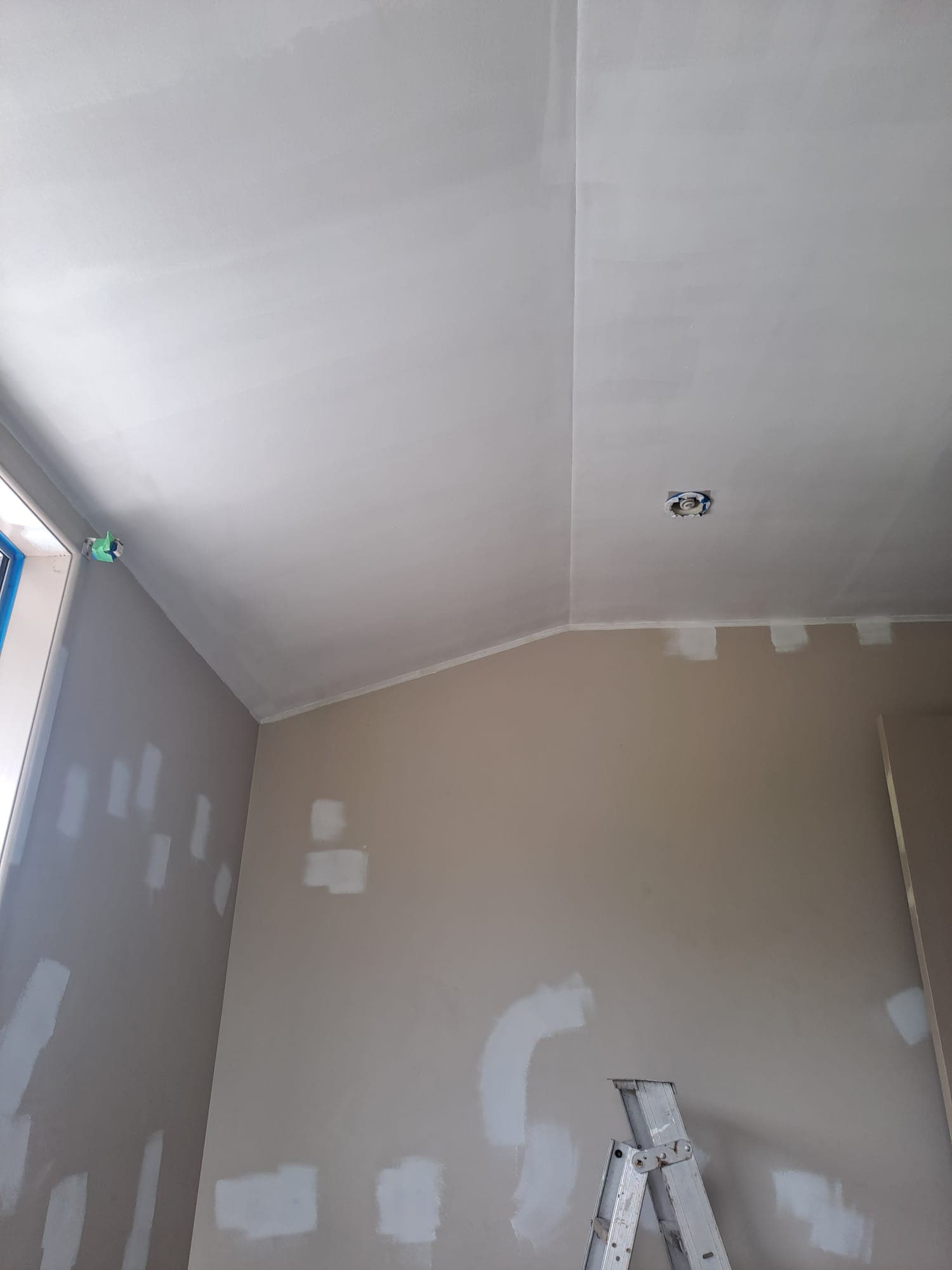 Interior room with patched walls and step ladder during ceiling painting prep - Ambient Civil Auckland
