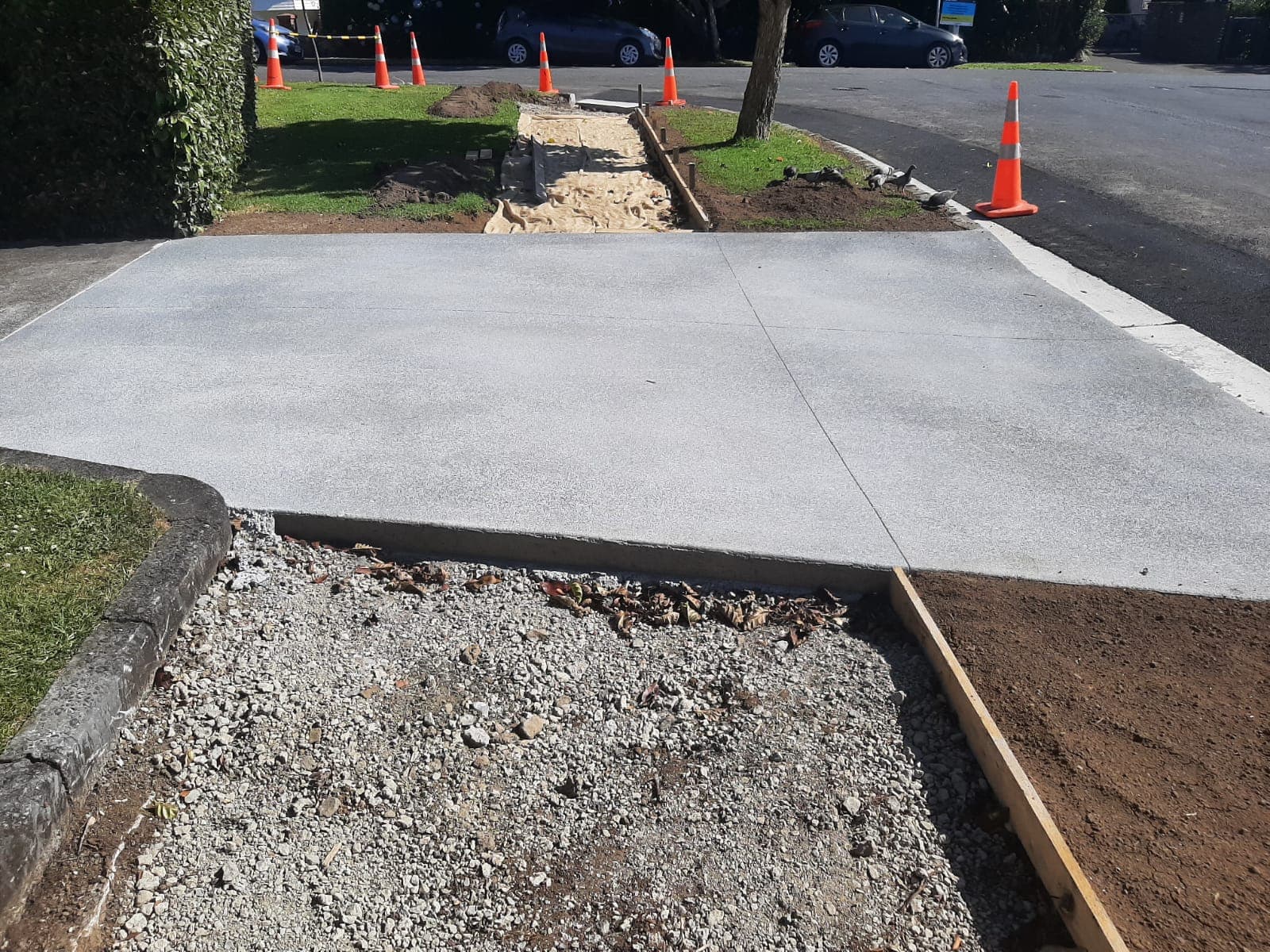 Freshly poured concrete driveway pad at the street edge with gravel base - Ambient Civil Auckland
