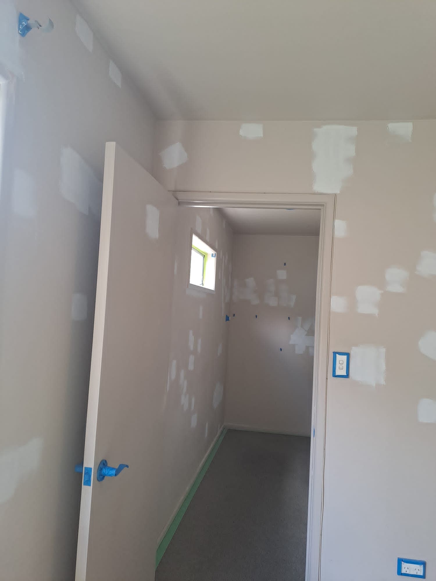 Hallway walls with filler patches over joints prepared for painting during interior repaint - Ambient Civil Auckland