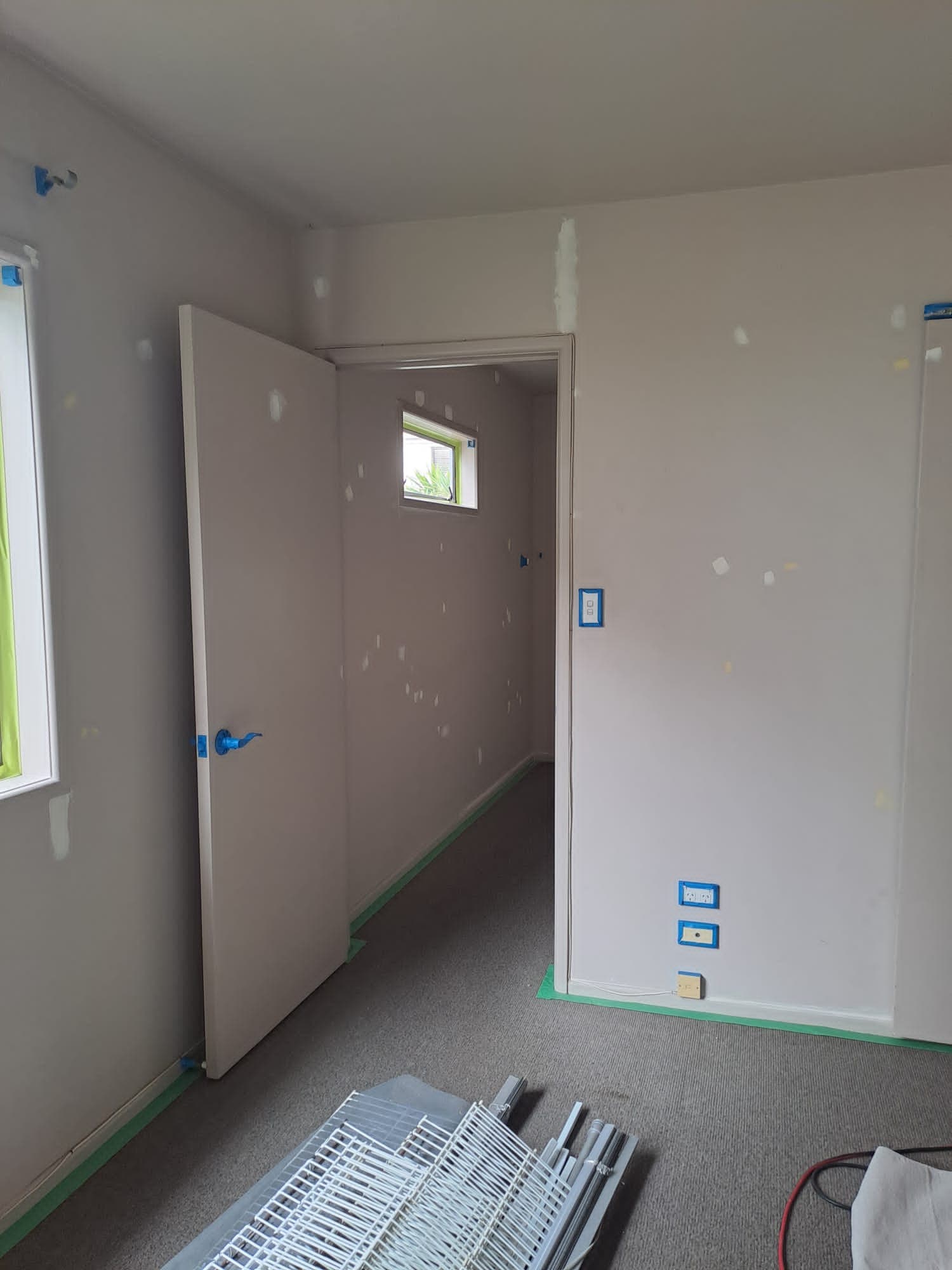 Bedroom and doorway with patched walls and masked fittings prepared for interior painting - Ambient Civil Auckland