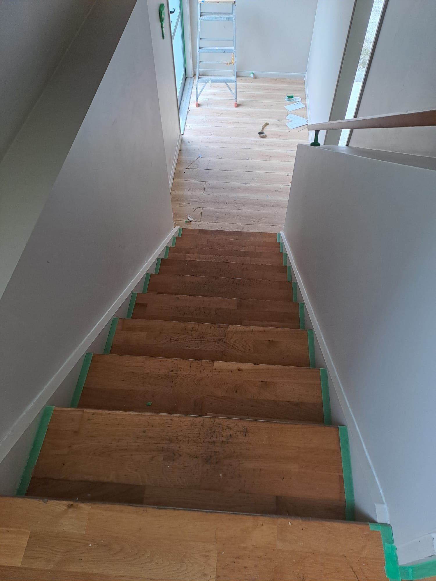Interior stairwell with masked timber treads and freshly painted white walls during a repaint - Ambient Civil Auckland