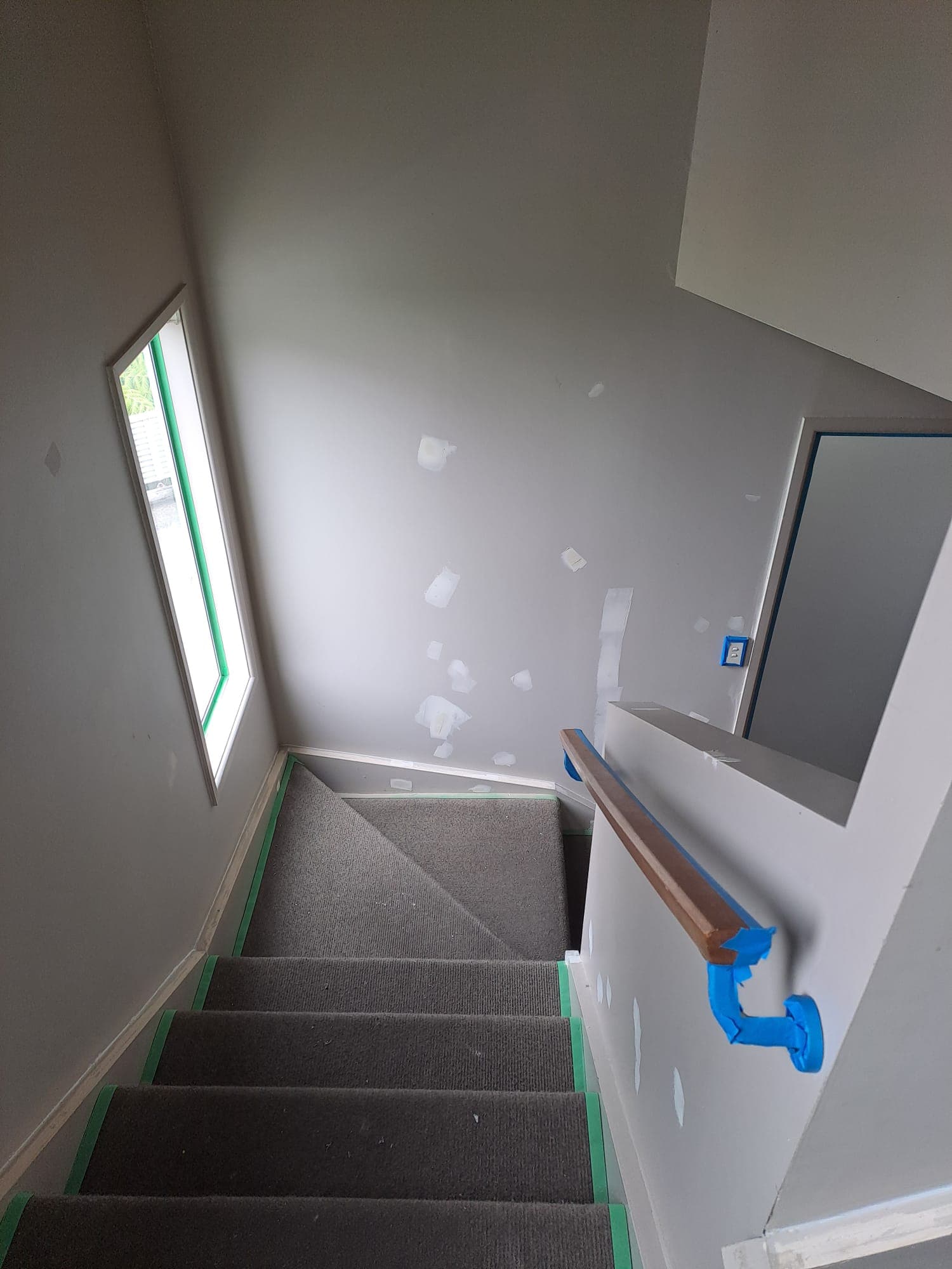 Carpeted stairwell with masked handrail and patched walls being prepped for painting - Ambient Civil Auckland
