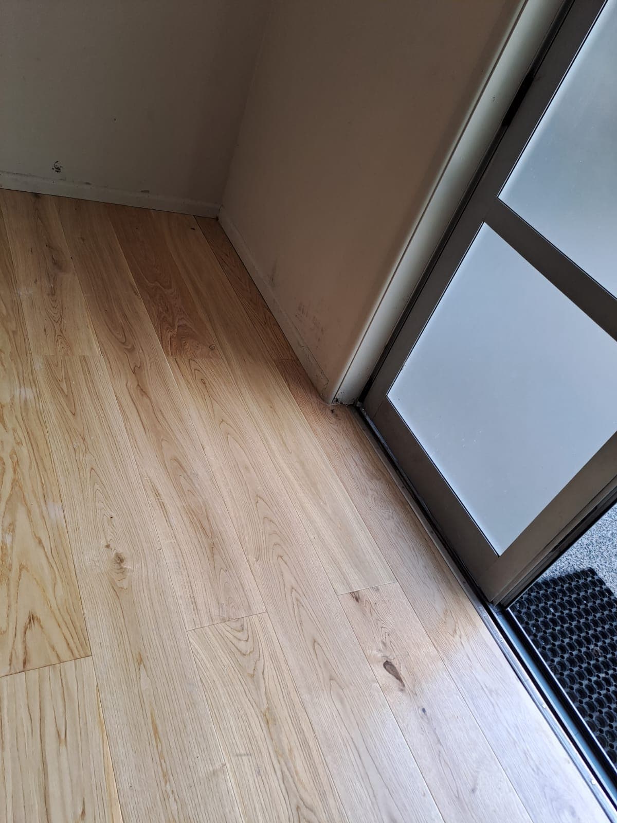 Timber laminate flooring at a glazed entry door after interior fit-out - Ambient Civil Auckland