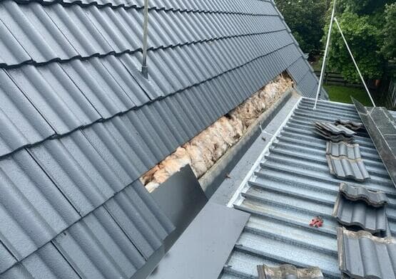 Roof replacement in progress with tiles removed and insulation exposed - Ambient Civil Auckland