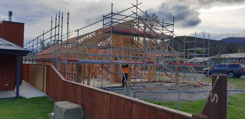 Timber-framed building under construction with scaffolding on site - Ambient Civil Auckland