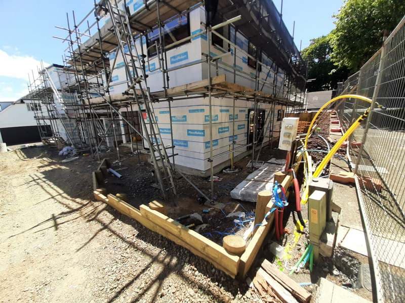 Two-storey house under construction with scaffolding and site services - Ambient Civil Auckland