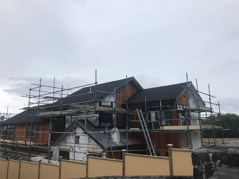 House under construction with scaffolding and cedar cladding - Ambient Civil Auckland