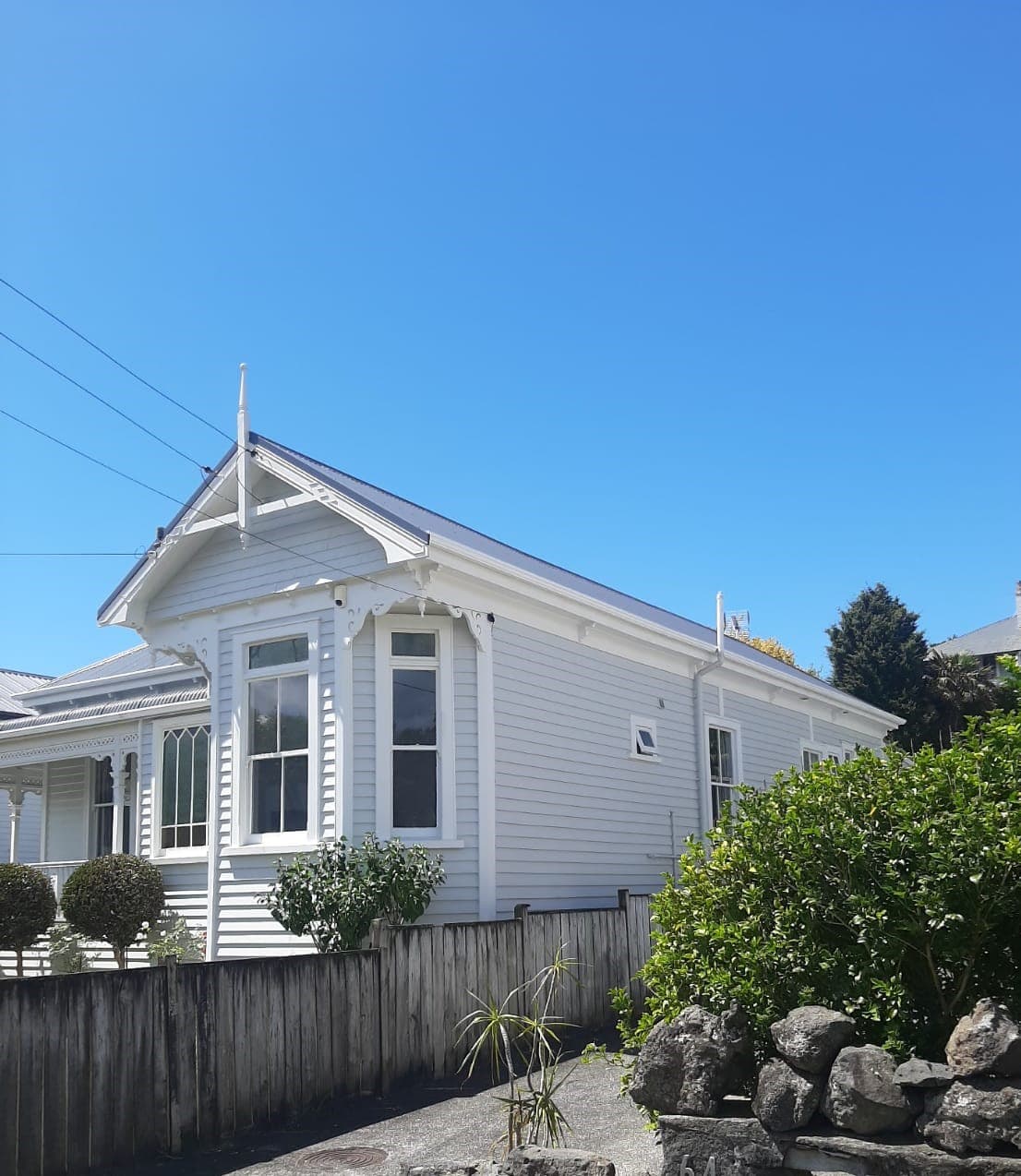 Restored white weatherboard villa with timber fence in Auckland - Ambient Civil Auckland