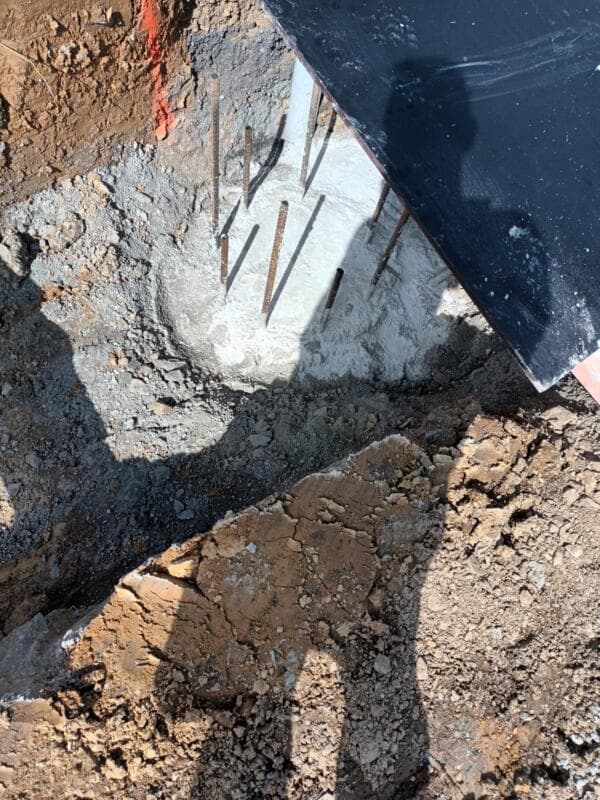 Concrete foundation pad with protruding rebar dowels in excavated pit - Ambient Civil Auckland