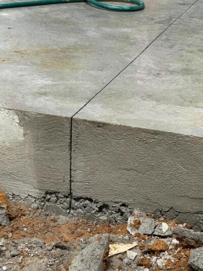 Finished concrete slab edge with tooled control joint and floated foundation face - Ambient Civil Auckland