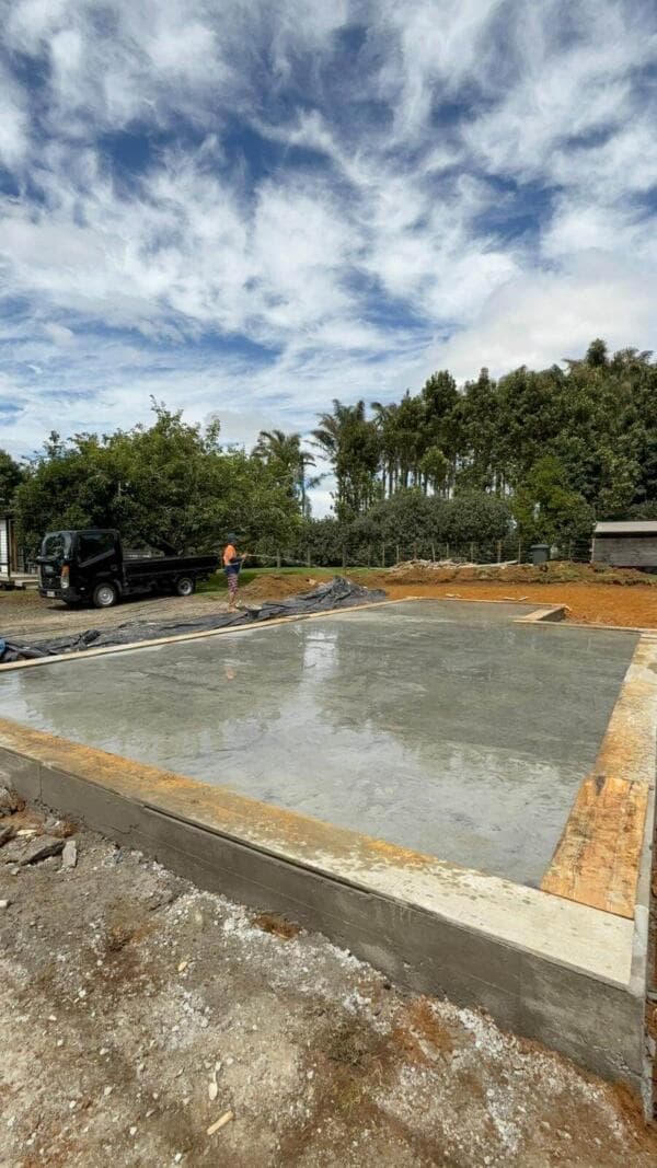 Wide view of a finished concrete slab and foundation on a cleared rural building site - Ambient Civil Auckland