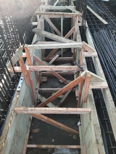 Timber bracing formwork between steel rebar cages on a concrete construction site - Ambient Civil Auckland