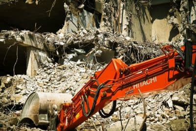 Hitachi excavator demolishing a concrete building - Ambient Civil Auckland