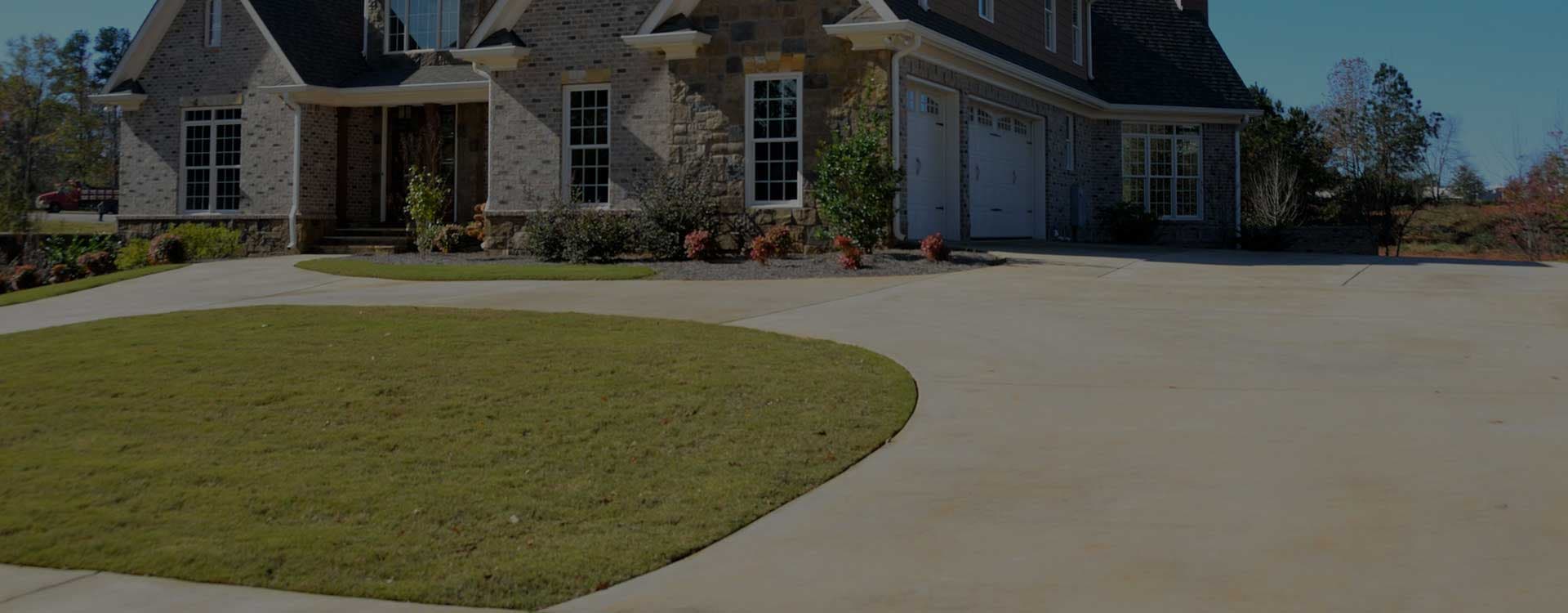Wide concrete driveway in front of a brick home in Auckland - Ambient Civil Auckland