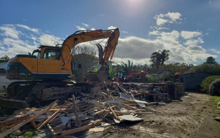 Hyundai excavator demolishing a residential house in an Auckland suburb - Ambient Civil Auckland
