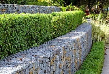 Gabion rock retaining wall in a landscaped garden - Ambient Civil Auckland