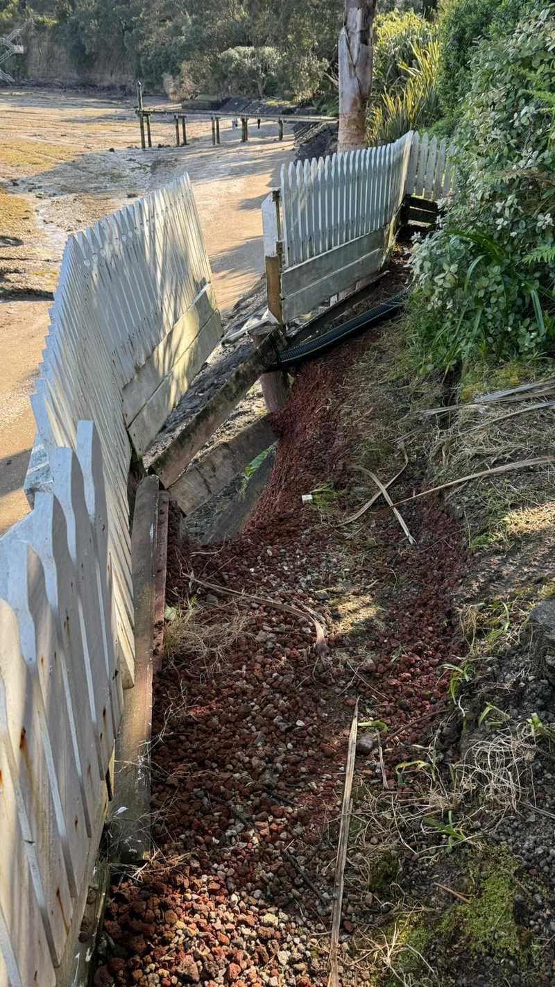 Concrete and timber retaining wall with eroded drainage channel on a coastal slope - Ambient Civil Auckland