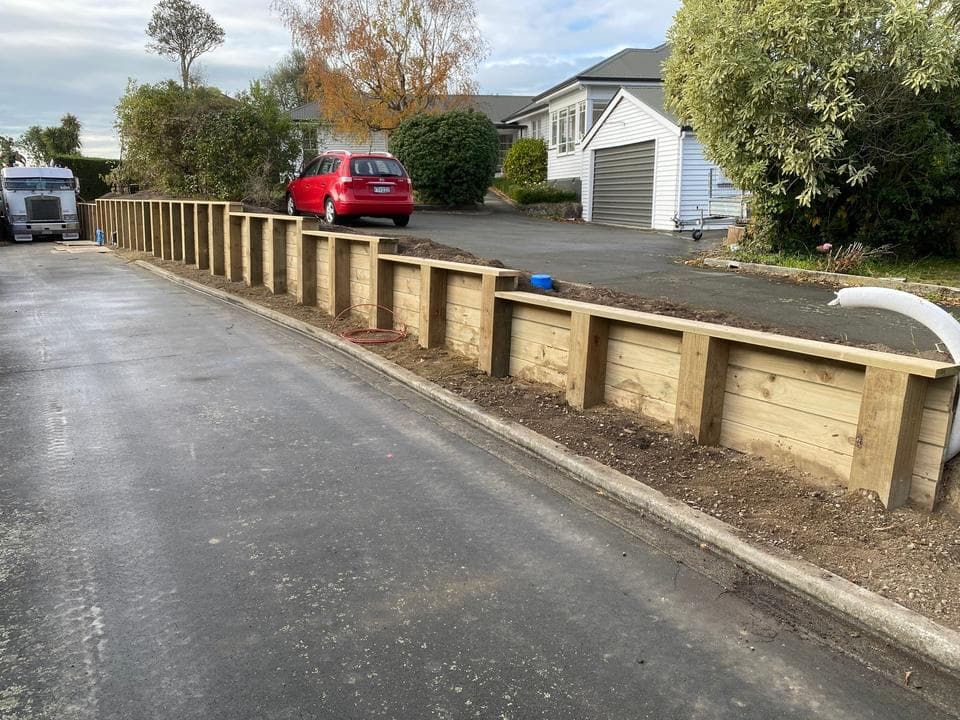 Newly built timber retaining wall along residential street kerb - Ambient Civil Auckland