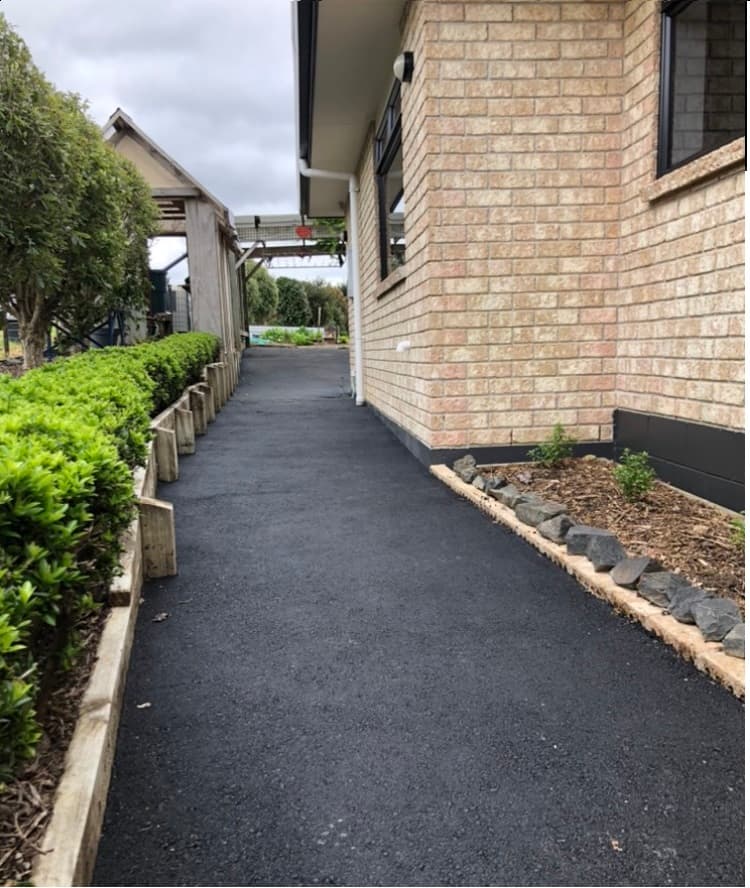 Newly laid asphalt driveway alongside a brick home in Auckland - Ambient Civil Auckland