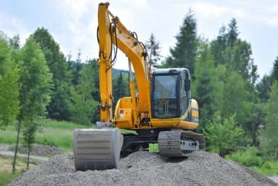 Yellow tracked excavator working on a gravel earthworks site - Ambient Civil Auckland