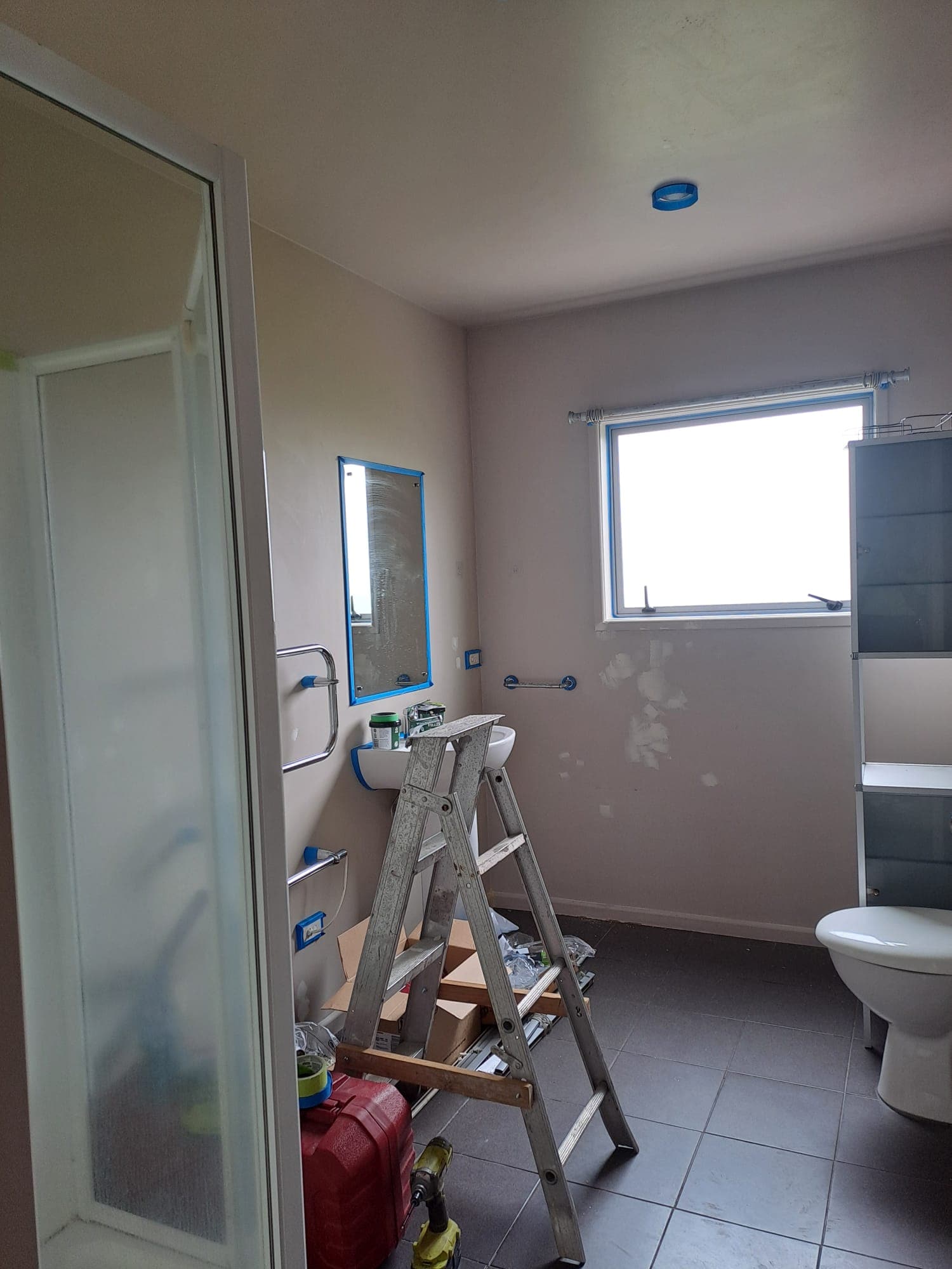 Bathroom being repainted with ladder taped mirror and shower enclosure during interior renovation - Ambient Civil Auckland