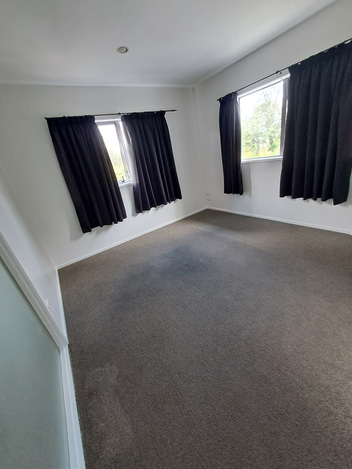 Completed bedroom with white painted walls, black curtains and grey carpet - Ambient Civil Auckland