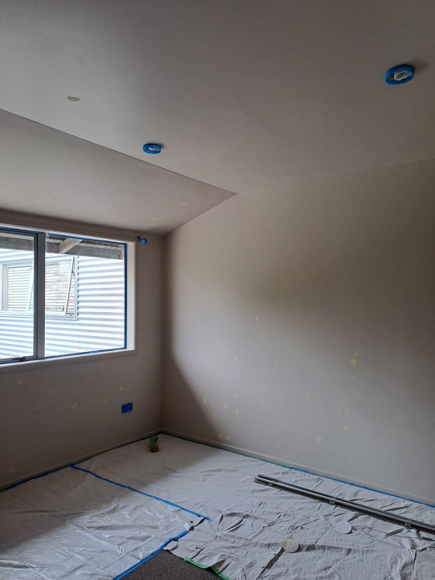 Bedroom wall patching and prep with drop sheets and masked downlights - Ambient Civil Auckland