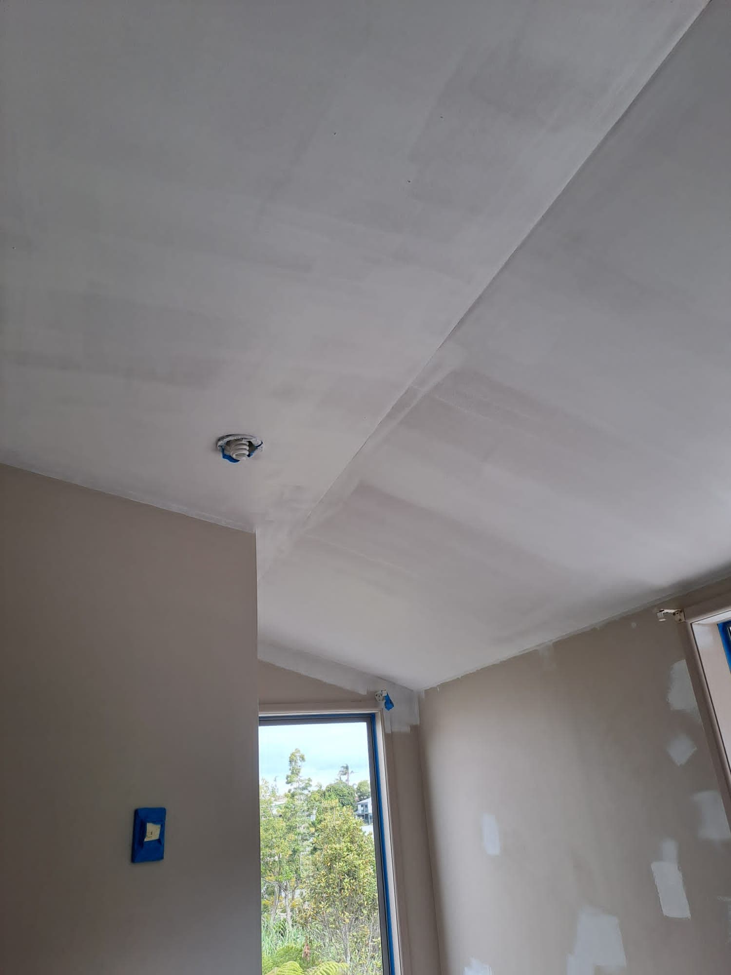 Freshly painted white ceiling and patched walls during an interior room repaint - Ambient Civil Auckland