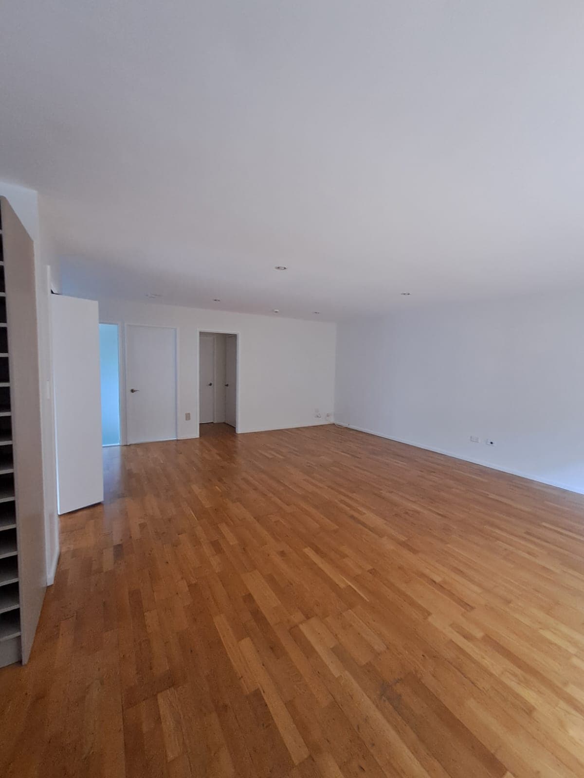Spacious finished living room with white walls and polished timber floor after interior repaint - Ambient Civil Auckland
