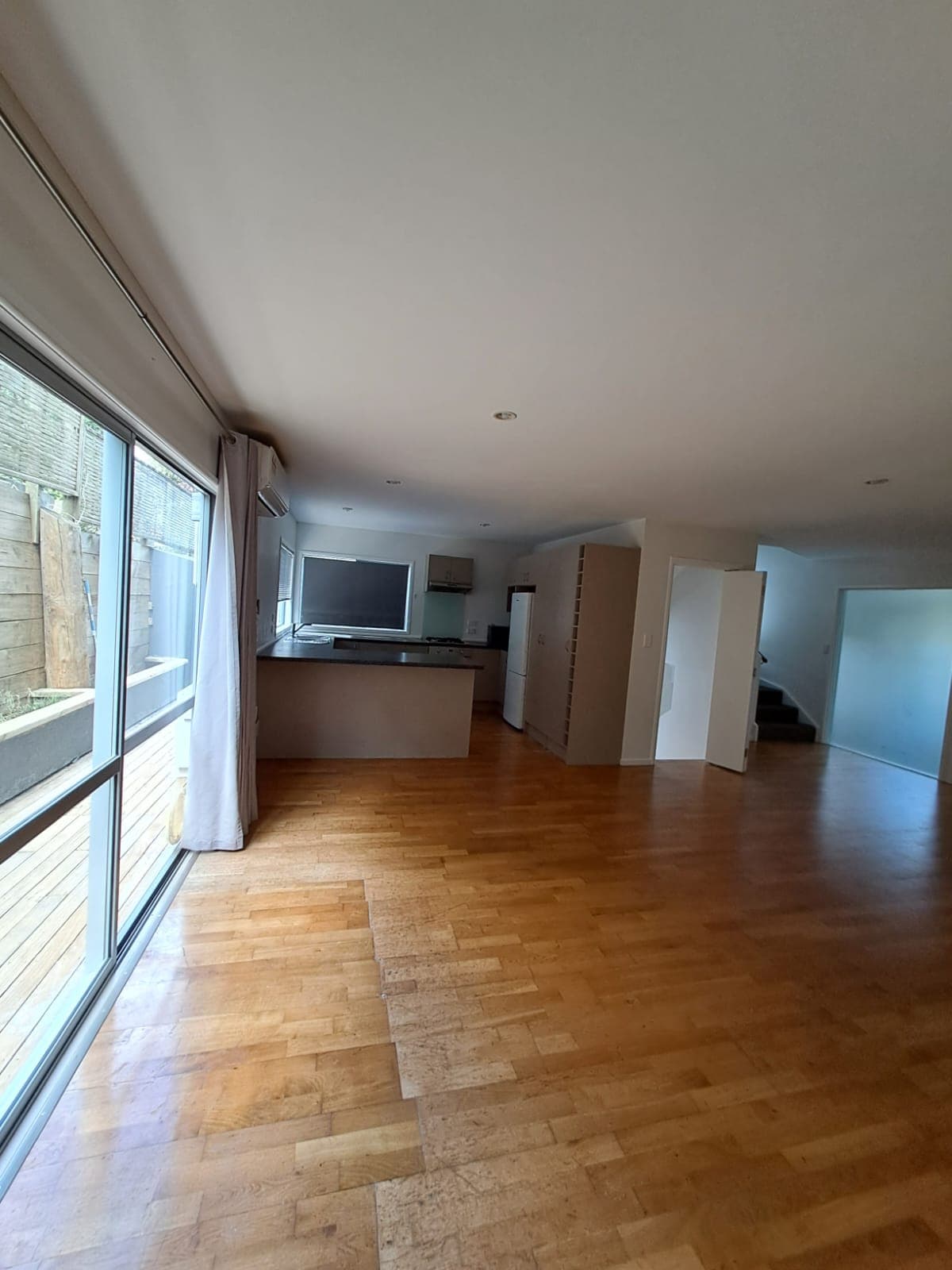 Repainted open-plan living and kitchen with parquet floor and island bench - Ambient Civil Auckland