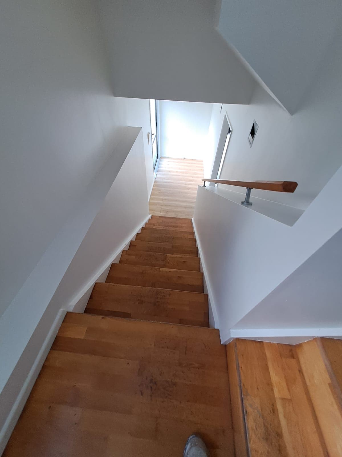 Timber staircase with freshly painted white walls leading to wood-floored hallway - Ambient Civil Auckland