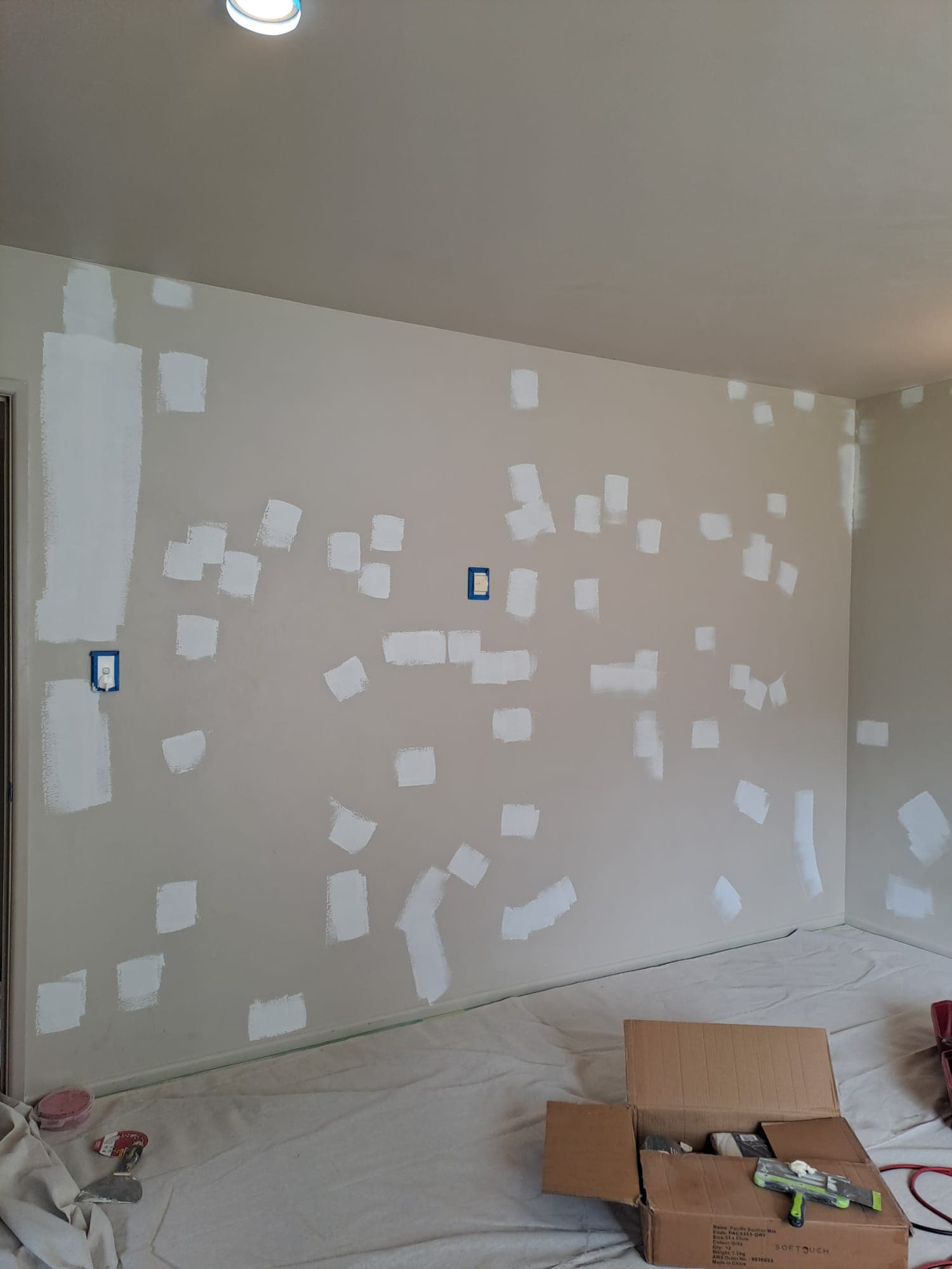 Interior wall covered in filler patches and masked power points during painting prep - Ambient Civil Auckland