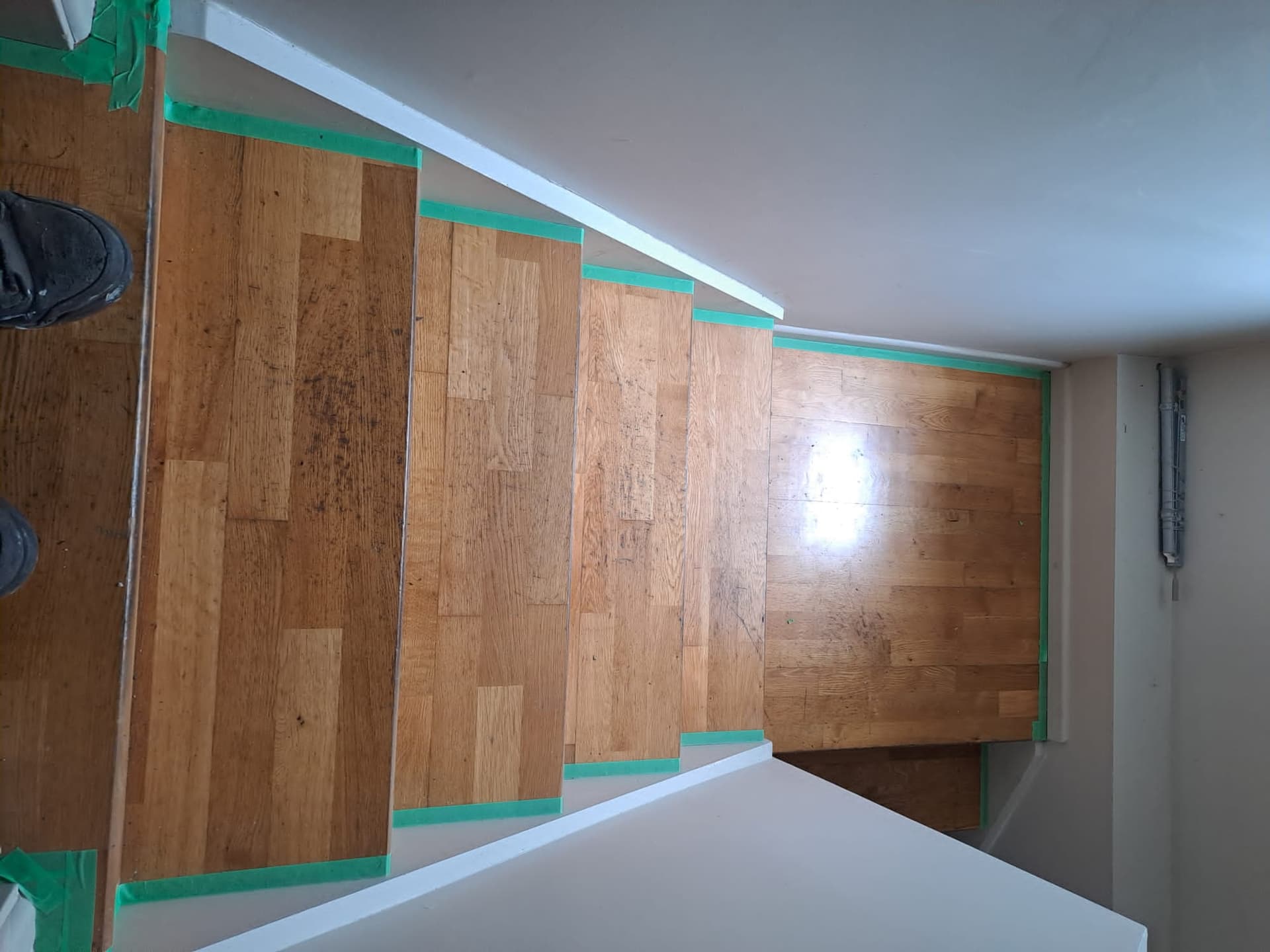 Timber staircase treads masked with painter's tape to protect them during interior painting - Ambient Civil Auckland