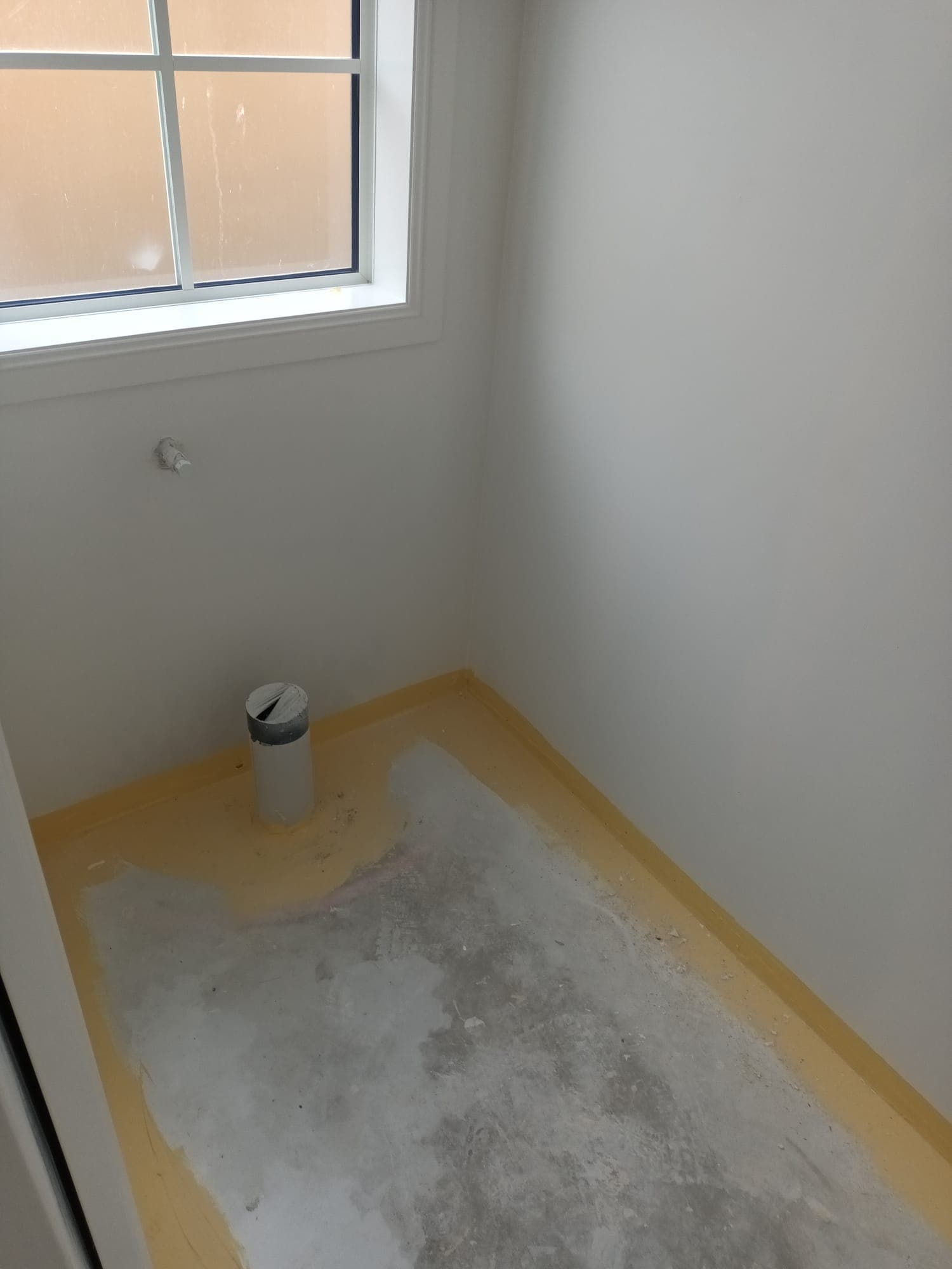 New-build bathroom floor prepped with masking and capped plumbing waste pipe before waterproofing - Ambient Civil Auckland