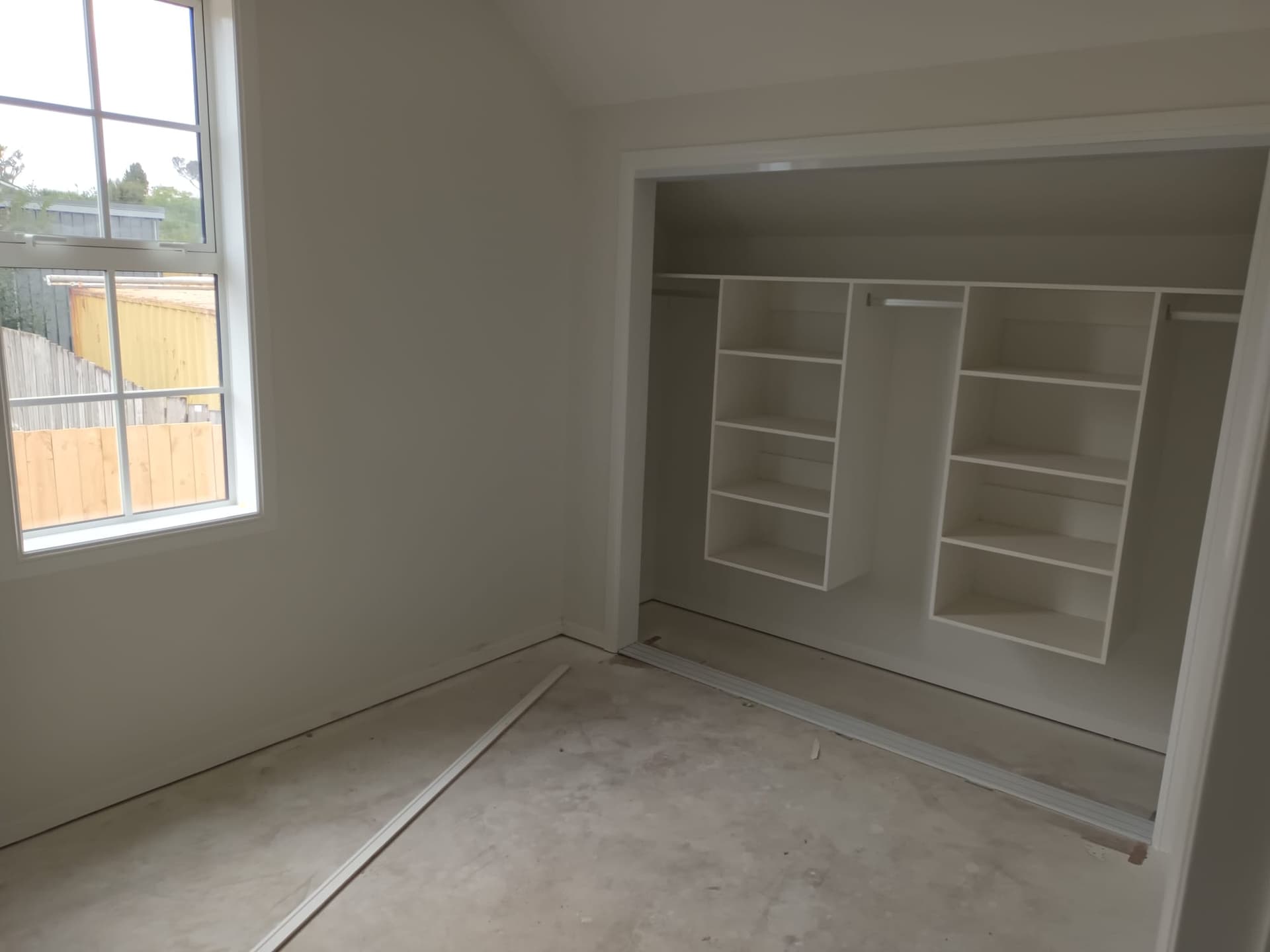 New-build bedroom with installed built-in wardrobe shelving and freshly painted walls - Ambient Civil Auckland