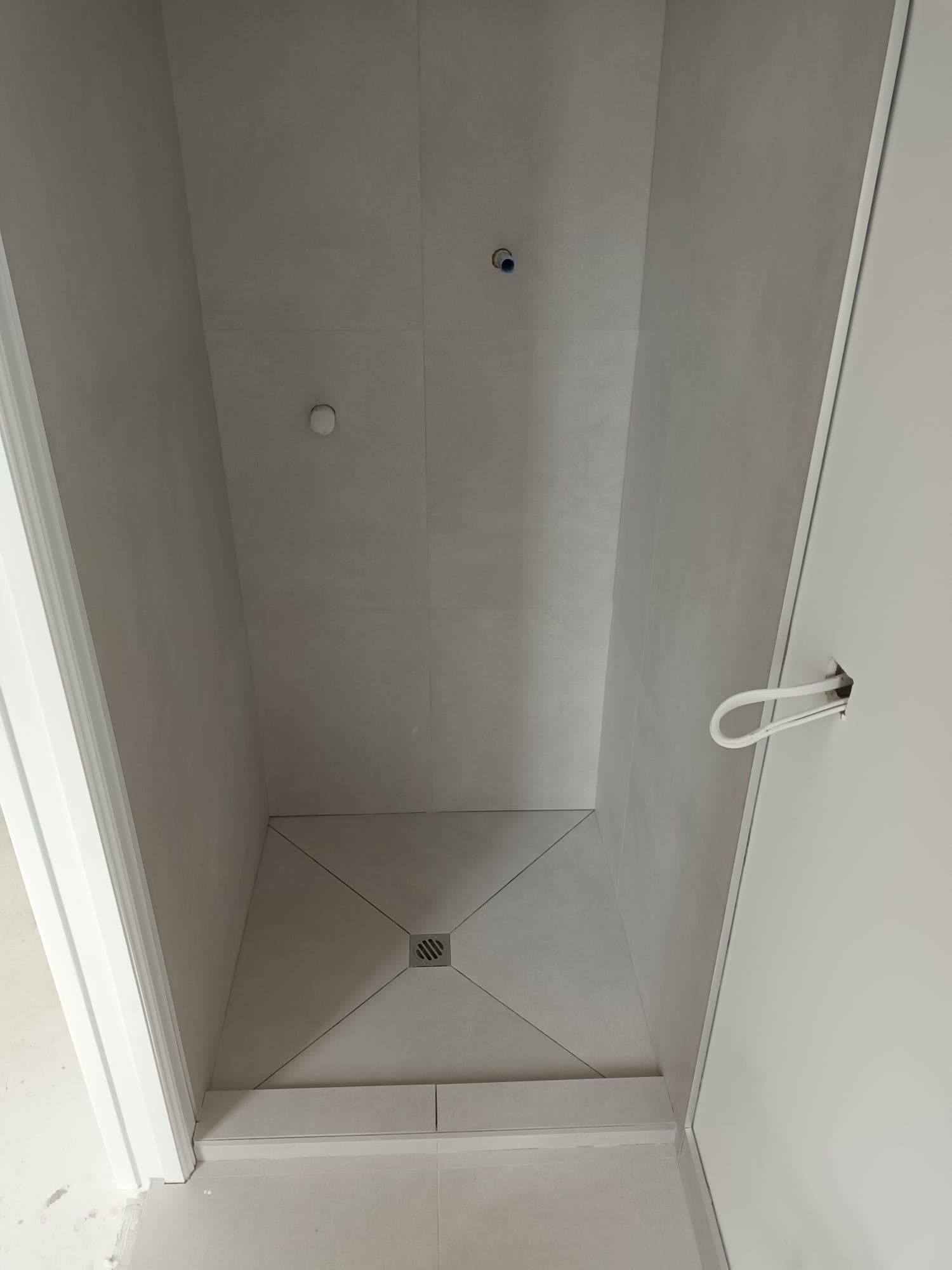 Tiled shower base with central drain and large-format wall tiles in a new build - Ambient Civil Auckland