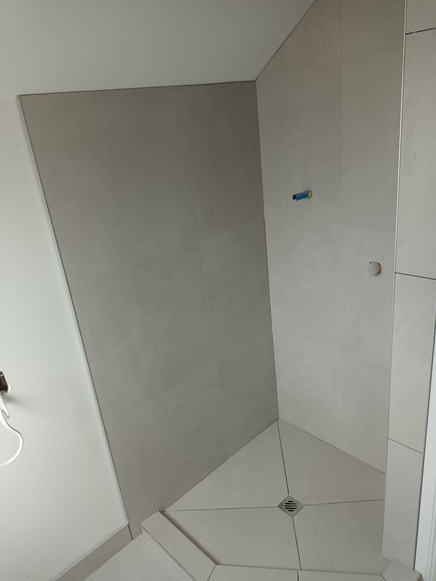 Large-format tile shower wall installation with roughed-in mixer in a new build - Ambient Civil Auckland