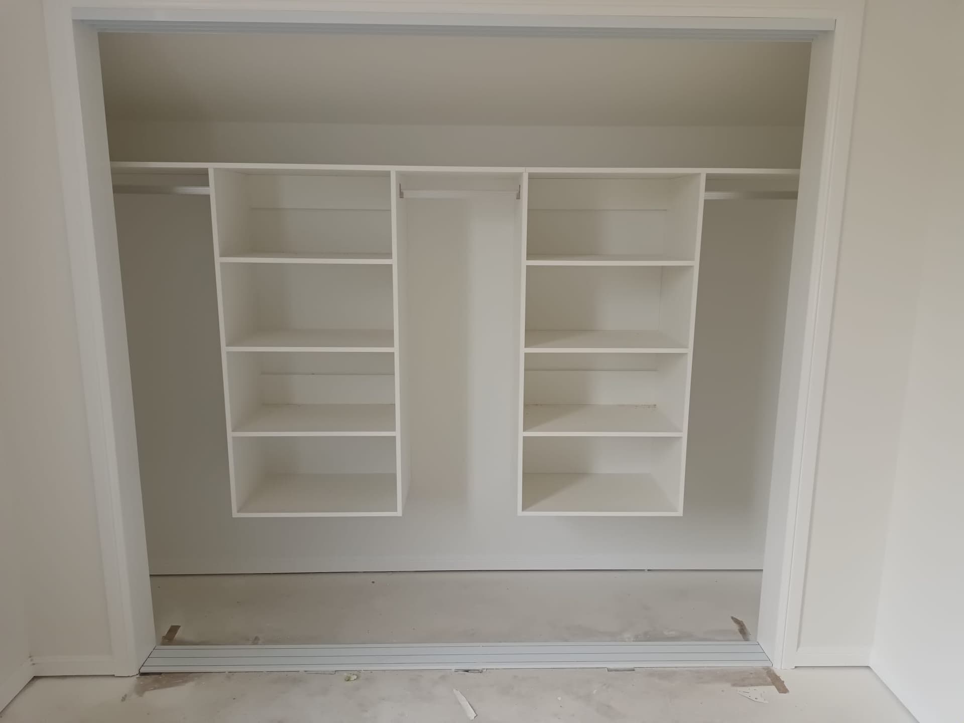 Built-in white wardrobe with shelving and hanging rails installed in a new bedroom - Ambient Civil Auckland