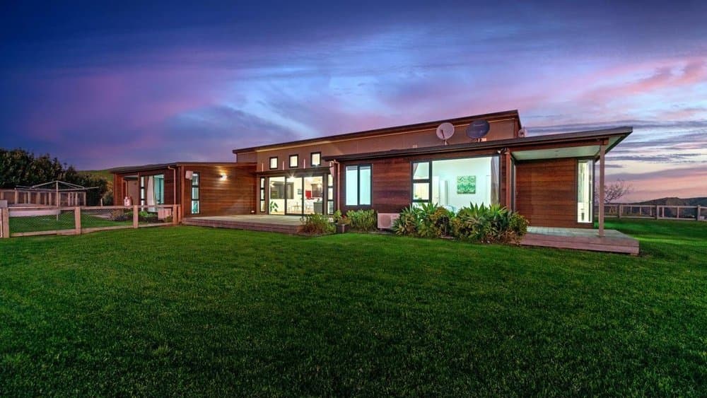 Modern timber-clad home with lawn at dusk in Auckland - Ambient Civil Auckland